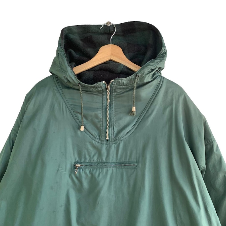 May include: A green hooded jacket with a zipper closure and a fleece lining. The jacket has a drawstring hood and a kangaroo pocket.