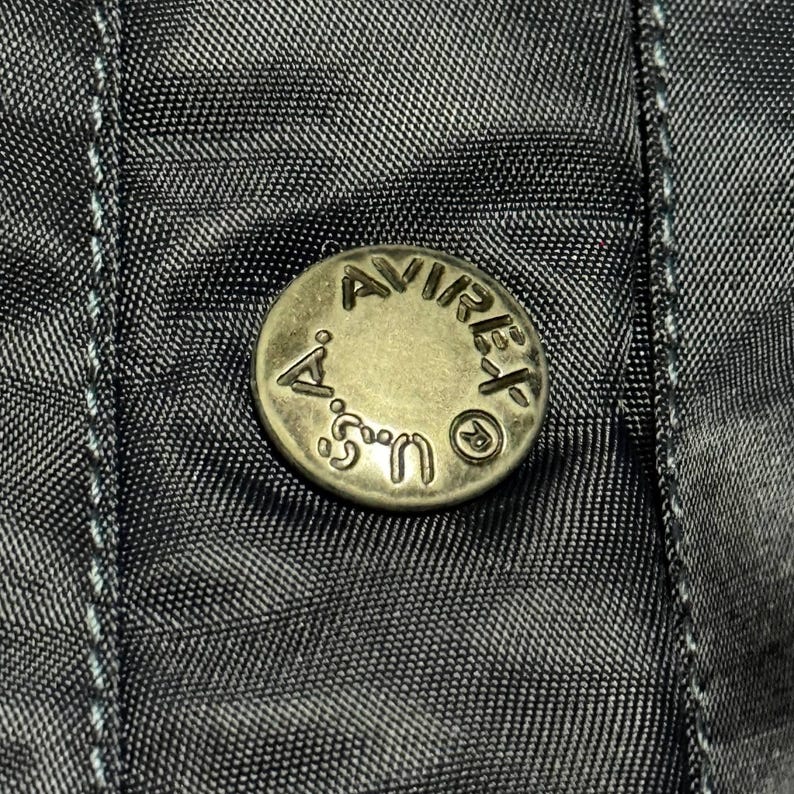 Vintage Avirex MA 1 Bomber Jacket Navy USA Flight Jacket 90s Streetwear Military Jacket Classic Zip Up Nylon Bomber Coat For Men And Women Rare Avirex USA Outerwear Piece With Iconic Back Logo Design.