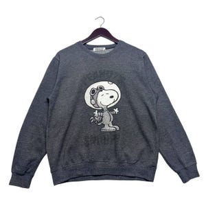 Sudadera vintage de Peanuts con Snoopy y astronauta, gris oscuro, cuello redondo, unisex, con estampado de la NASA y el espacio.