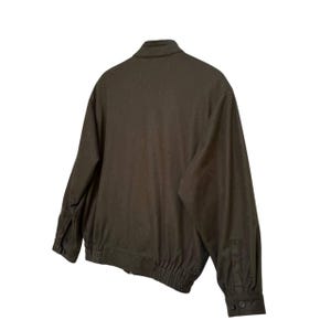 May include: A dark green bomber jacket with a zipper closure and ribbed cuffs and waistband.