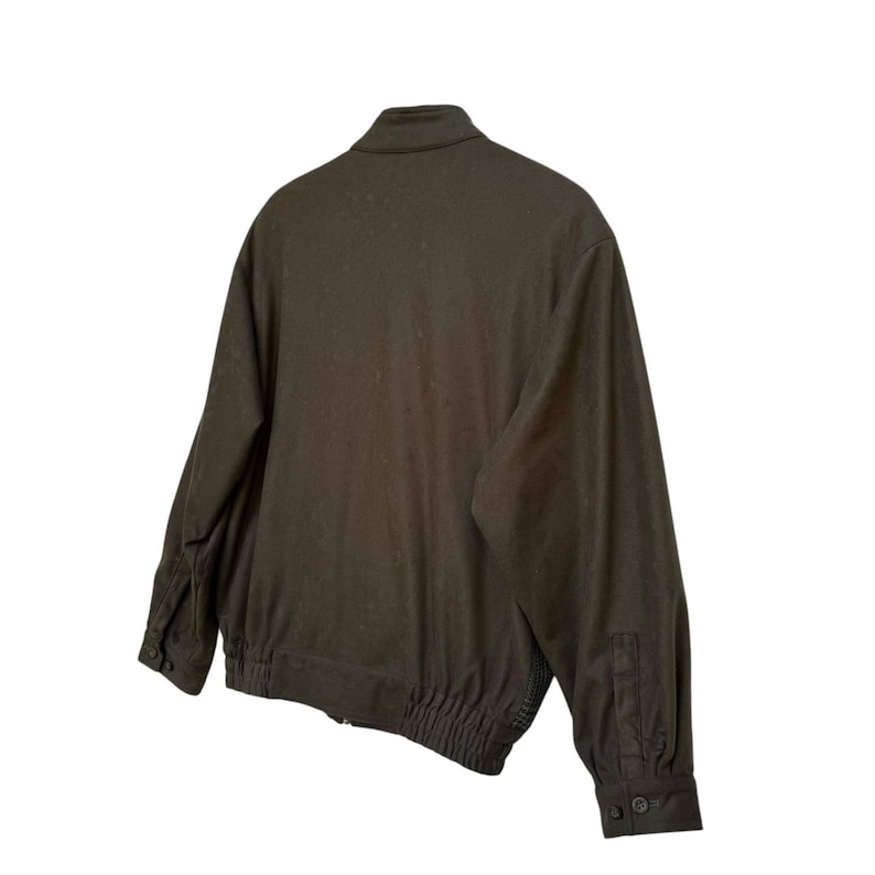 May include: A dark green bomber jacket with a zipper closure and ribbed cuffs and waistband.