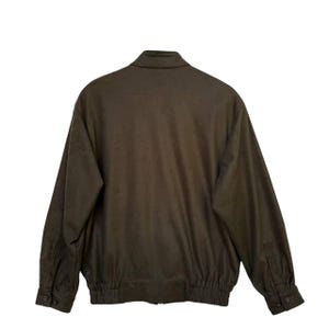 May include: A dark green bomber jacket with a zipper closure and elastic waistband.