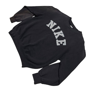 Vintage Nike crewneck sweatshirt featuring iconic spellout logo in classic black, Y2K sportswear style with relaxed unisex fit, perfect for streetwear, casual everyday wear, and vintage Nike collectors worldwide.