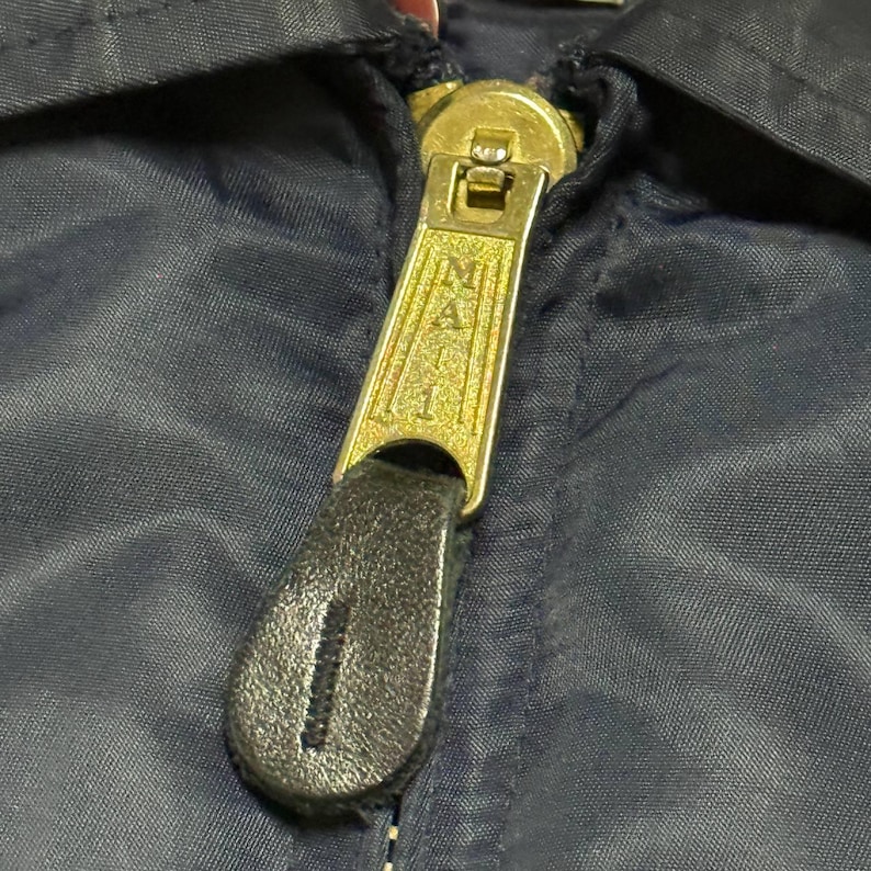 Vintage Avirex MA 1 Bomber Jacket Navy USA Flight Jacket 90s Streetwear Military Jacket Classic Zip Up Nylon Bomber Coat For Men And Women Rare Avirex USA Outerwear Piece With Iconic Back Logo Design.