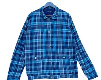 May include: A blue and white plaid button-up shirt jacket with a single chest pocket and two flap pockets.