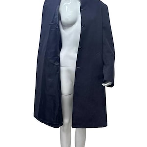 May include: A long, dark blue coat with a mandarin collar and a single button closure. The coat is lined in black.