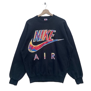 K&ouml;nnte beinhalten: Schwarzer Nike Air Sweatshirt mit einem bunten, abstrakten Nike Swoosh Logo und dem Wort "NIKE" in einer fetten, bunten Schrift.