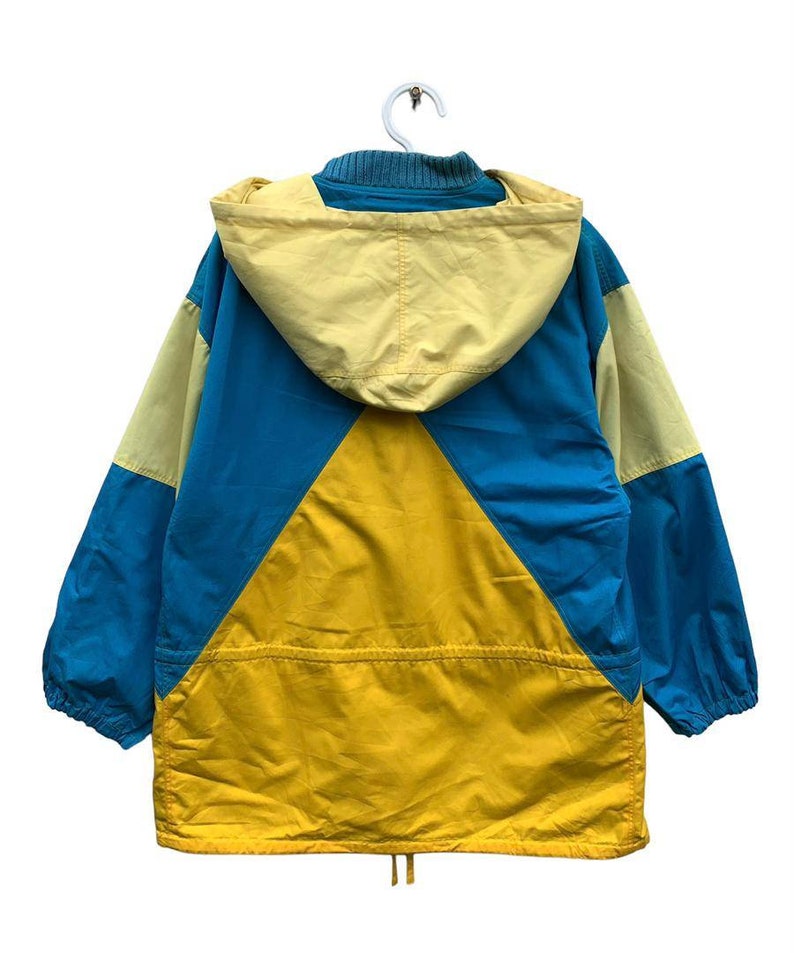 May include: A yellow, blue, and light yellow hooded jacket with a drawstring at the bottom.