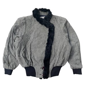 May include: A vintage black and white striped jacket with a black faux fur collar and trim. The jacket has a ribbed hem and cuffs, and features three buttons down the front. The sleeves are slightly puffed at the shoulders.