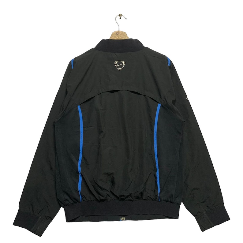 May include: Black windbreaker jacket with blue accents and a Nike logo on the back.