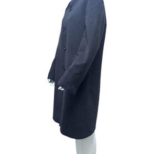 May include: A long-sleeved, dark gray coat with a mandarin collar and button closure. The coat is made of a soft, textured fabric.
