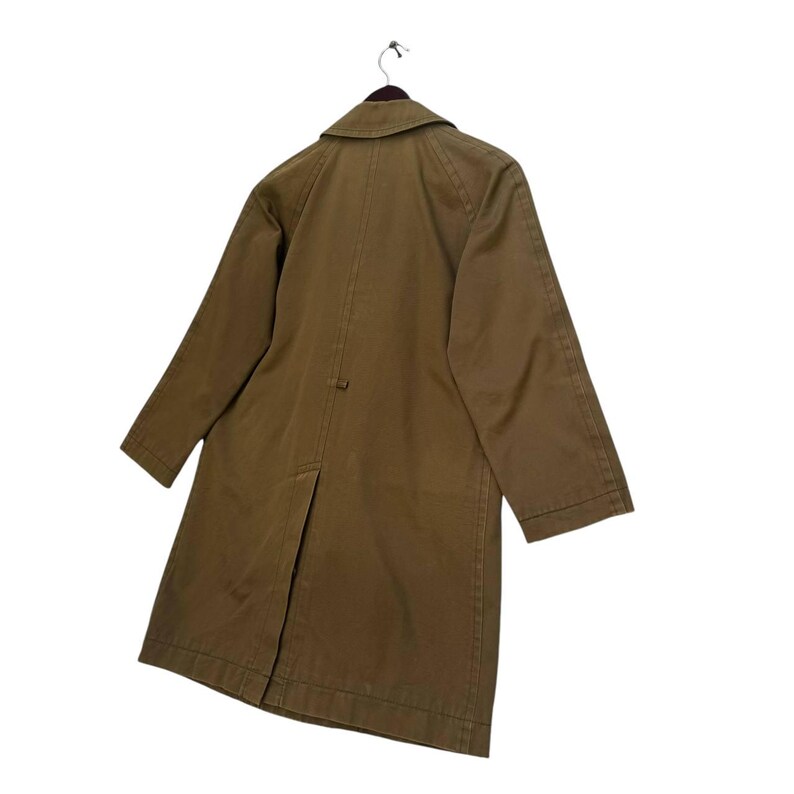 May include: An olive-green long coat hanging on a hanger. The coat features a classic collar, long sleeves, and a split vent at the back. The coat is made of a durable fabric, and the back view is shown.