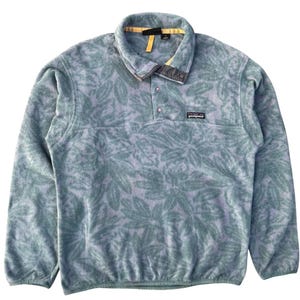May include: A light blue fleece pullover with a leaf pattern. The pullover has a button-up collar, a small logo patch, and long sleeves. The collar has a yellow trim.