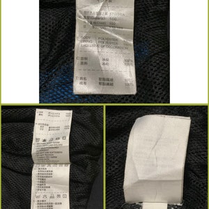 May include: A black and blue jacket with a white tag that says "Made in India" and includes size and fabric information in English and Japanese.