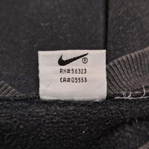 Vintage Nike crewneck sweatshirt featuring iconic spellout logo in classic black, Y2K sportswear style with relaxed unisex fit, perfect for streetwear, casual everyday wear, and vintage Nike collectors worldwide.