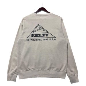 May include: A light gray sweatshirt with a black triangle logo that says "KELTY ESTABLISHED 1952 U.S.A."