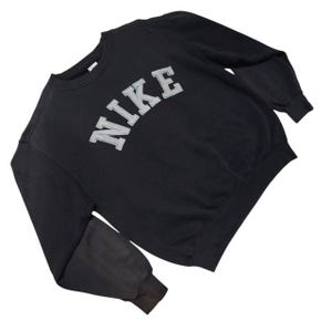Vintage Nike crewneck sweatshirt featuring iconic spellout logo in classic black, Y2K sportswear style with relaxed unisex fit, perfect for streetwear, casual everyday wear, and vintage Nike collectors worldwide.