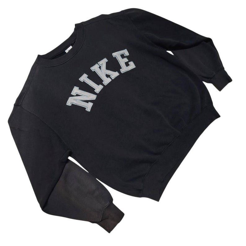 Vintage Nike crewneck sweatshirt featuring iconic spellout logo in classic black, Y2K sportswear style with relaxed unisex fit, perfect for streetwear, casual everyday wear, and vintage Nike collectors worldwide.