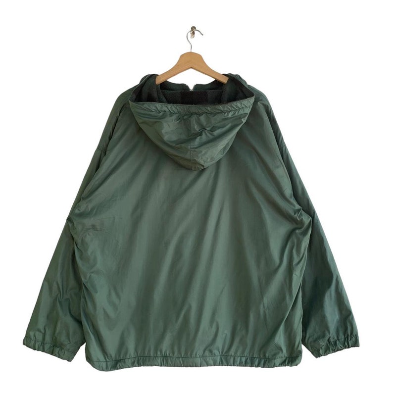 May include: A green hooded jacket with a zipper closure. The jacket has a fleece lining and a drawstring hood.