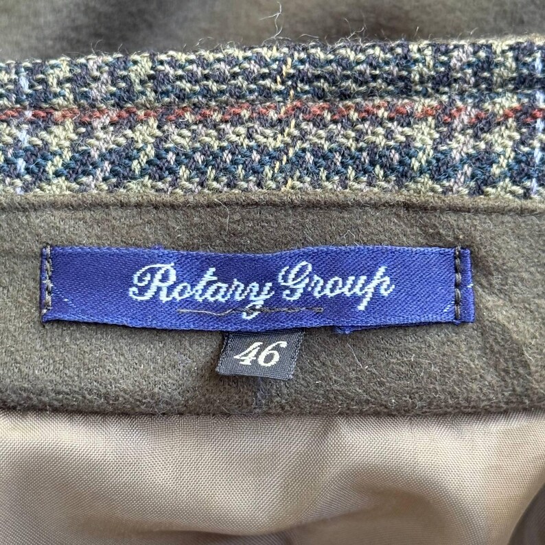 May include: A brown tweed skirt with a blue label that says "Rotary Group" and a black tag with the number "46" on it.