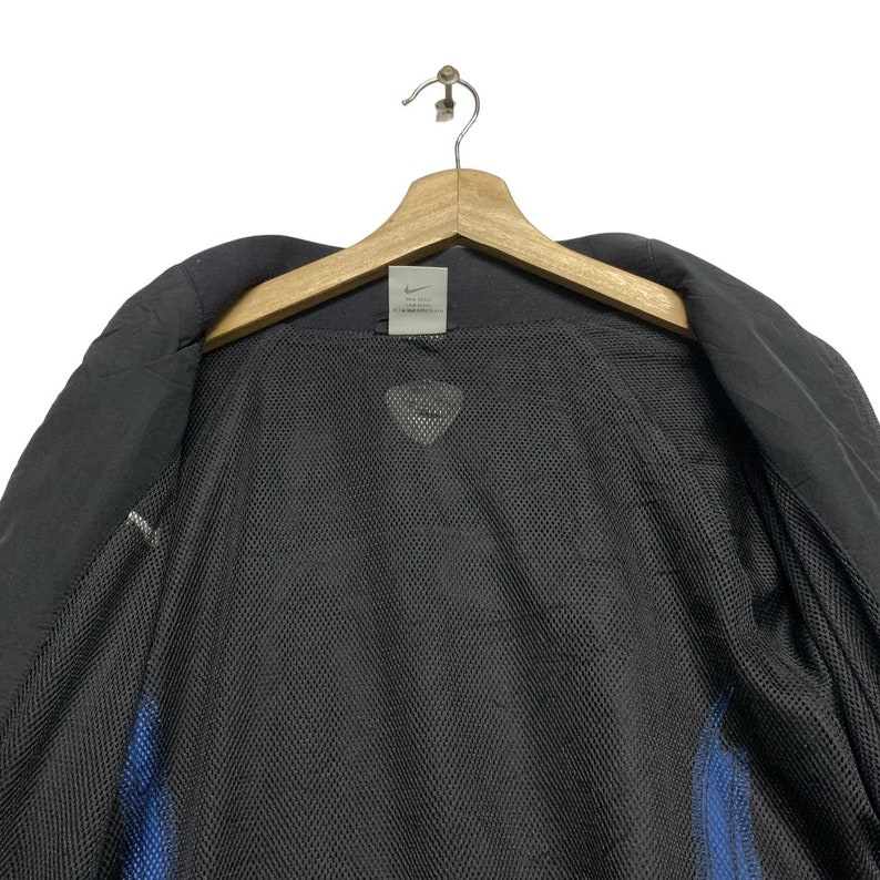 May include: Black jacket with a mesh lining and a Nike logo tag. The tag says "The Swoosh" and "Nike" in white text.