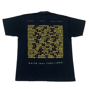 May include: Black t-shirt with a yellow and pink graphic print listing cities from around the world. The text "Join the Joyride" is at the top of the graphic. The text "World Tour 1991-1992" is at the bottom of the graphic.