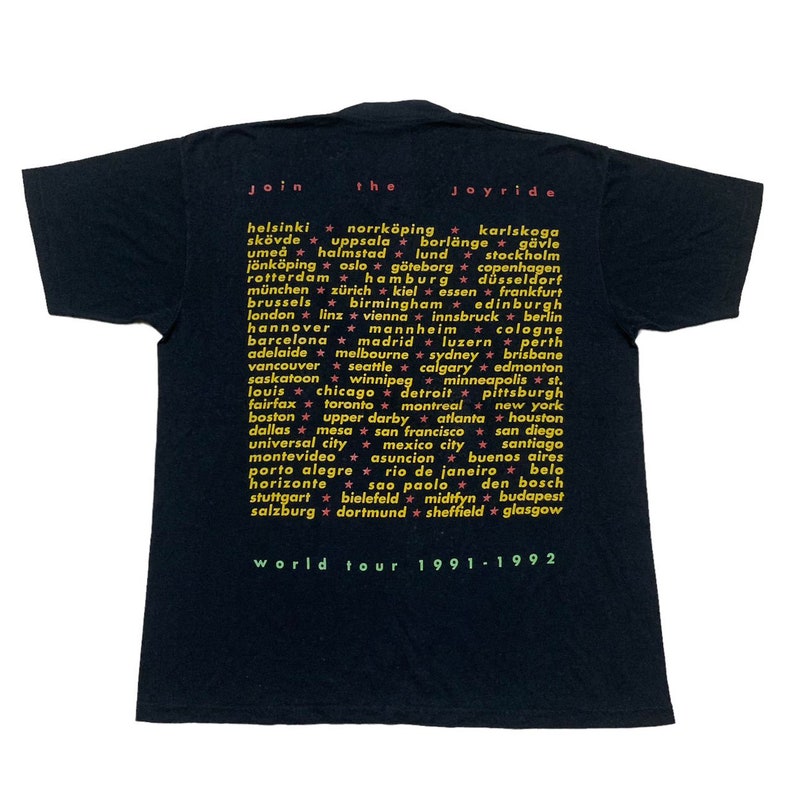 May include: Black t-shirt with a yellow and pink graphic print listing cities from around the world. The text "Join the Joyride" is at the top of the graphic. The text "World Tour 1991-1992" is at the bottom of the graphic.
