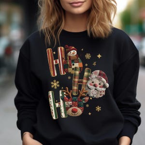 May include: Black sweatshirt with a festive "HO HO HO" design. The letters are decorated with a snowman, Santa, and reindeer, along with snowflakes and stars. The design incorporates plaid and patchwork patterns, creating a cozy holiday theme.