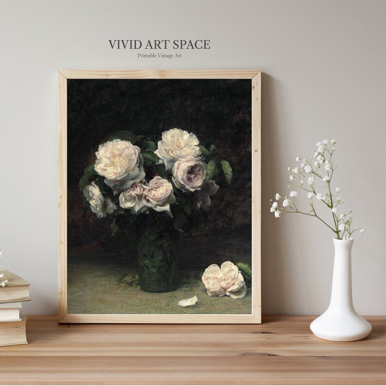 May include: A vintage painting of a bouquet of white roses in a green vase. The roses are arranged in a vase on a dark green table. The painting is framed in a light wood frame.