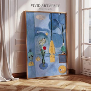 May include: A framed print of a blue abstract painting with yellow and red accents. The artwork features a vase of flowers, a yellow sculpture, and a small green lamp. The text "VIVID ART SPACE Printable Vintage Art" is at the top.