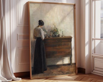 May include: A framed vintage art print titled "VIVID ART SPACE Printable Vintage Art." The artwork depicts a woman in a long black skirt and white blouse, reading by a wooden dresser with candles and flowers. The painting has a warm, neutral color palette.