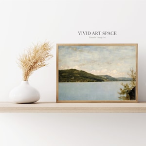 Pu&ograve; includere: Un dipinto di paesaggio vintage di un lago con una catena montuosa sullo sfondo. Il cielo &egrave; blu con nuvole bianche. Il lago &egrave; di colore azzurro chiaro e le montagne sono verdi. Il dipinto &egrave; incorniciato in una cornice di legno.