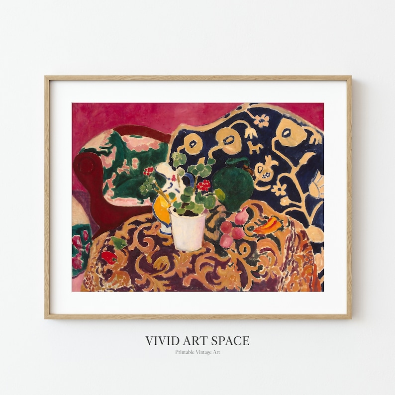 May include: A still life painting of a floral arrangement in a white pot on a table with a patterned tablecloth. The table is next to a red couch with a blue and gold patterned cushion. The background is a vibrant pink.