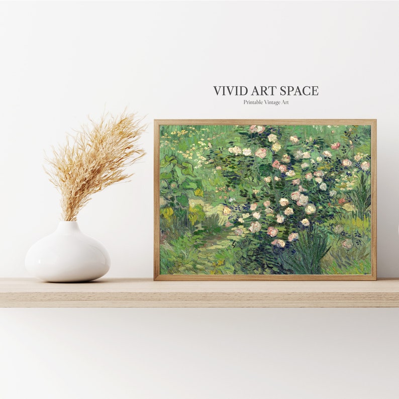 Puede incluir: Una impresi&oacute;n enmarcada de una escena de jard&iacute;n con rosas rosas y follaje verde. La obra de arte est&aacute; en un marco de madera y se exhibe en un estante de color claro. Un jarr&oacute;n blanco con hierba de la pampa seca est&aacute; a la izquierda de la obra de arte. El texto "VIVID ART SPACE" est&aacute; en la parte superior.
