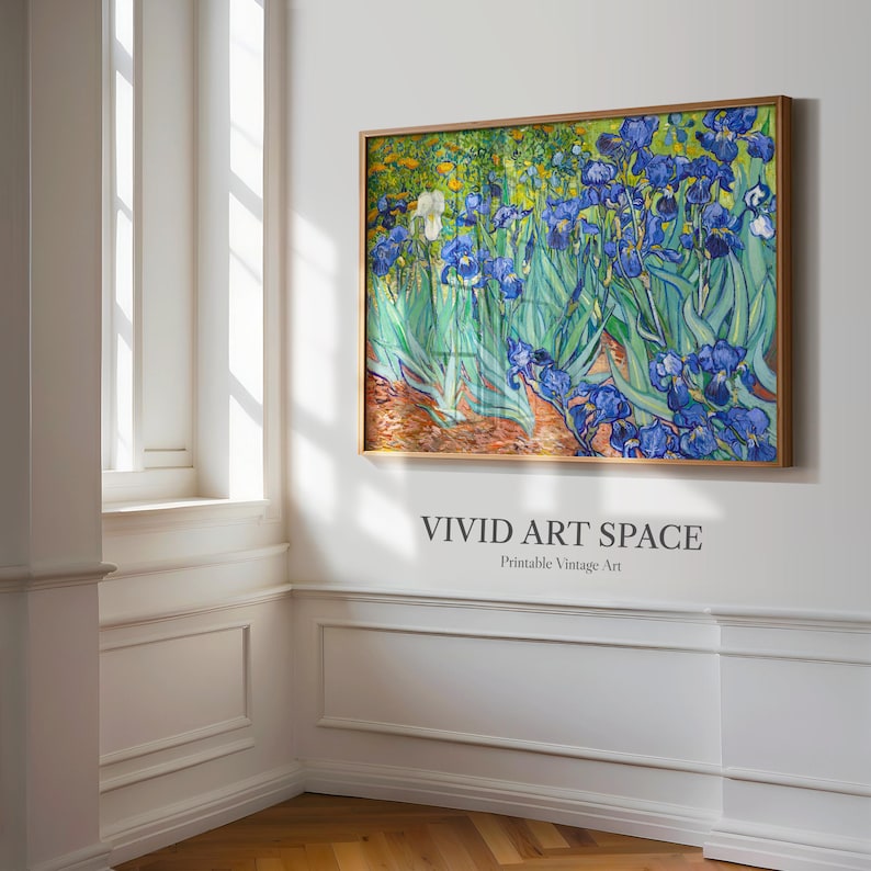 May include: A framed print of a painting featuring blue irises and green foliage. The artwork, in a gold-colored frame, is mounted on a white wall. The text "VIVID ART SPACE Printable Vintage Art" is below the painting.