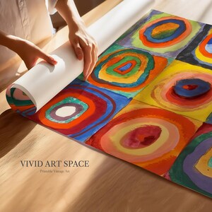 May include: A colorful abstract art print with concentric circles in squares, featuring vibrant hues of red, blue, yellow, and green. The print is being unrolled, revealing the words "VIVID ART SPACE" and "Printable Vintage Art".