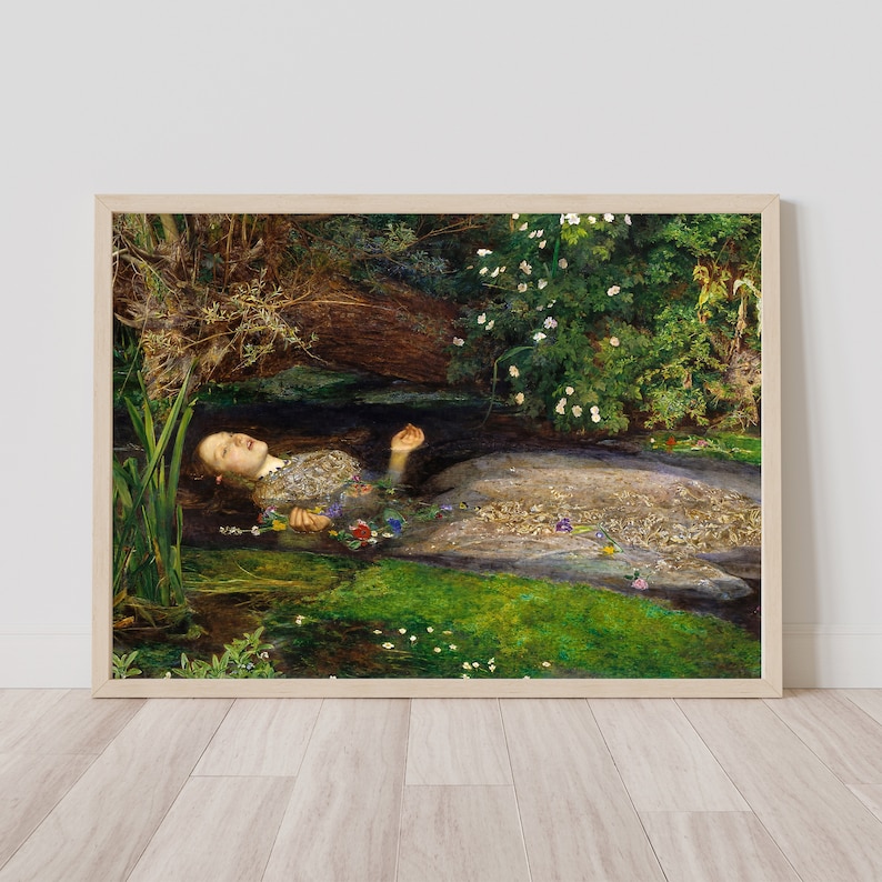 K&ouml;nnte beinhalten: Gerahmter Kunstdruck, der eine Frau in einem detaillierten Kleid zeigt, die in Wasser treibt, umgeben von Blumen und Gr&uuml;n. Das Kunstwerk spielt in einer nat&uuml;rlichen, &auml;u&szlig;eren Umgebung. Der Druck wird in einem Holzrahmen pr&auml;sentiert.