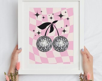 Peut inclure: Une impression encadrée représentant deux cerises boule à facettes sur un fond à carreaux roses et blancs avec des étoiles noires. L'impression est encadrée dans un cadre blanc.