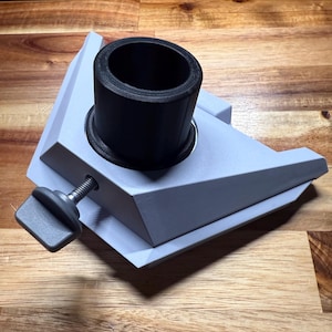 May include: A gray 3D printed base with a black plastic cylinder on top. The base has a knob on the side for adjusting the height of the cylinder.