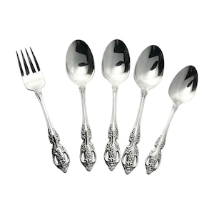 May include: A set of silver-colored flatware, including four spoons and one fork, arranged on a white background. The utensils have ornate, detailed handles with a floral design.