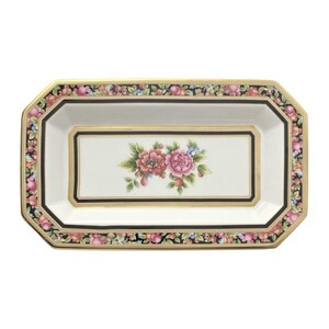 May include: A white rectangular serving tray with a gold rim and black floral border. The center of the tray features a floral design with pink and red flowers.