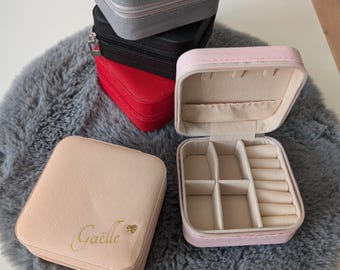 Op de afbeelding: Vier kleine juwelendoosjes, twee zijn gesloten en twee zijn open. De open doosjes hebben compartimenten voor ringen en oorbellen. Eén doosje is roze, één is beige, één is rood en één is zwart.