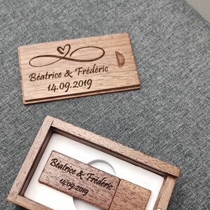 Op de afbeelding: Een houten doos met een USB-stick erin. De doos en de stick zijn gegraveerd met de tekst "Beatrice & Fr&eacute;d&eacute;ric 14.09.2019".