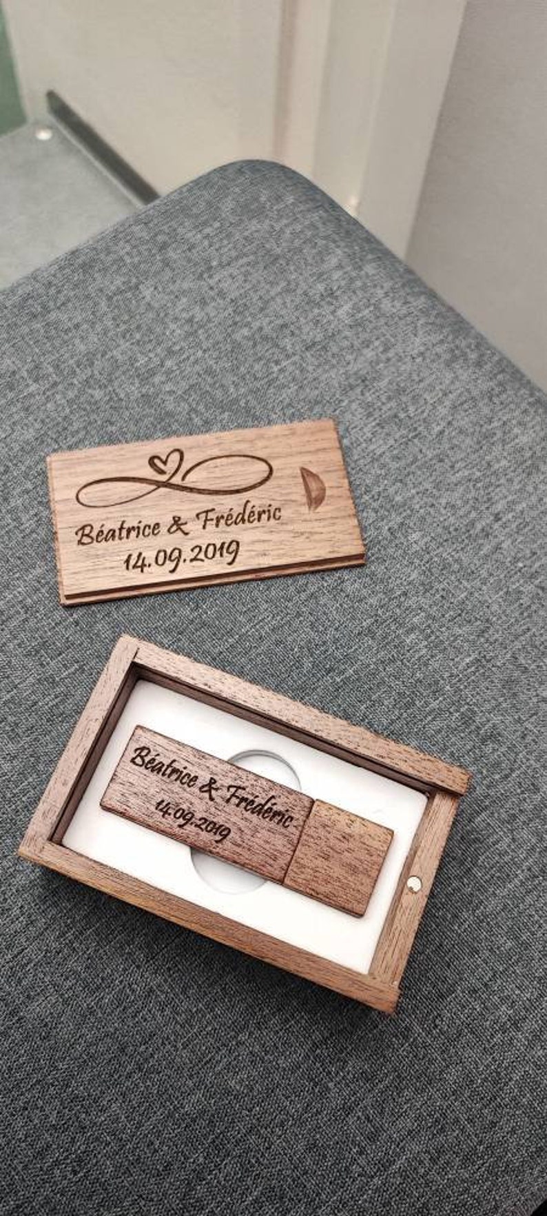 Op de afbeelding: Een houten doos met een USB-stick erin. De doos en de stick zijn gegraveerd met de tekst "Beatrice & Fr&eacute;d&eacute;ric 14.09.2019".