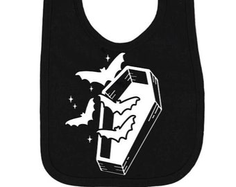 May include: Black cotton baby bib with a white design of a coffin with bats flying around it.
