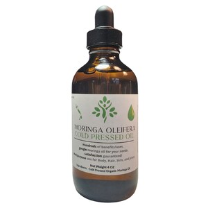 May include: A brown glass bottle with a dropper top, labeled "Moringa Oleifera Cold Pressed Oil". The label also includes the text "Hundreds of benefits/uses. google moringa oil for your needs. satisfaction guaranteed! Multipurpose use for Body, Hair, Skin, and joints. Net Weight 4 OZ. Ingredients: Cold Pressed Organic Moringa Oil."