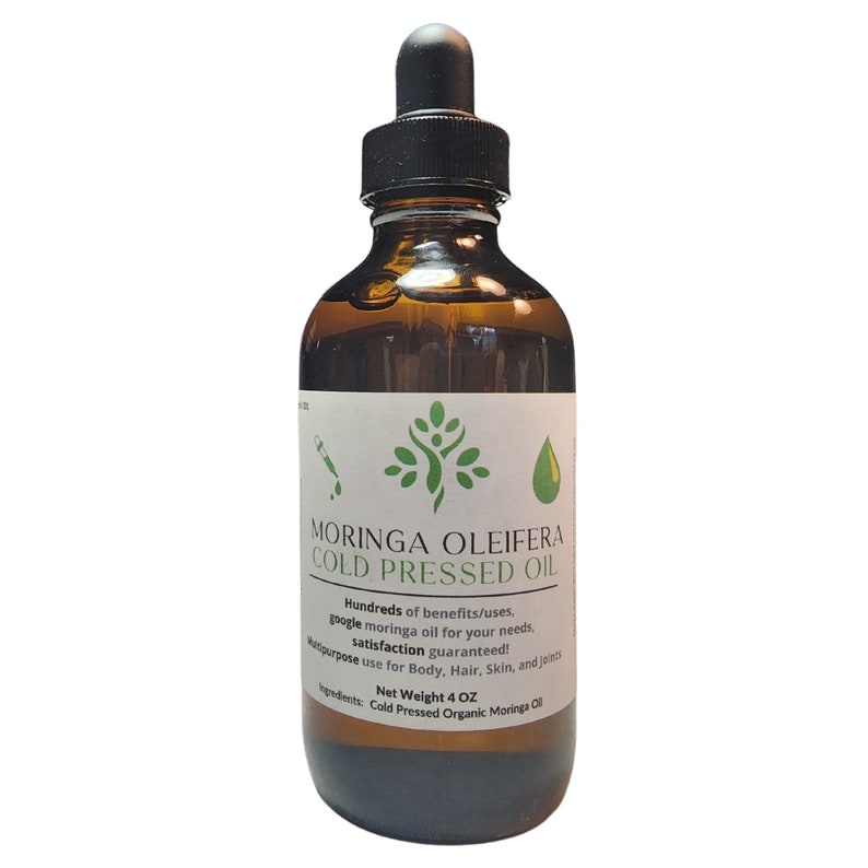 May include: A brown glass bottle with a dropper top, labeled "Moringa Oleifera Cold Pressed Oil". The label also includes the text "Hundreds of benefits/uses. google moringa oil for your needs. satisfaction guaranteed! Multipurpose use for Body, Hair, Skin, and joints. Net Weight 4 OZ. Ingredients: Cold Pressed Organic Moringa Oil."