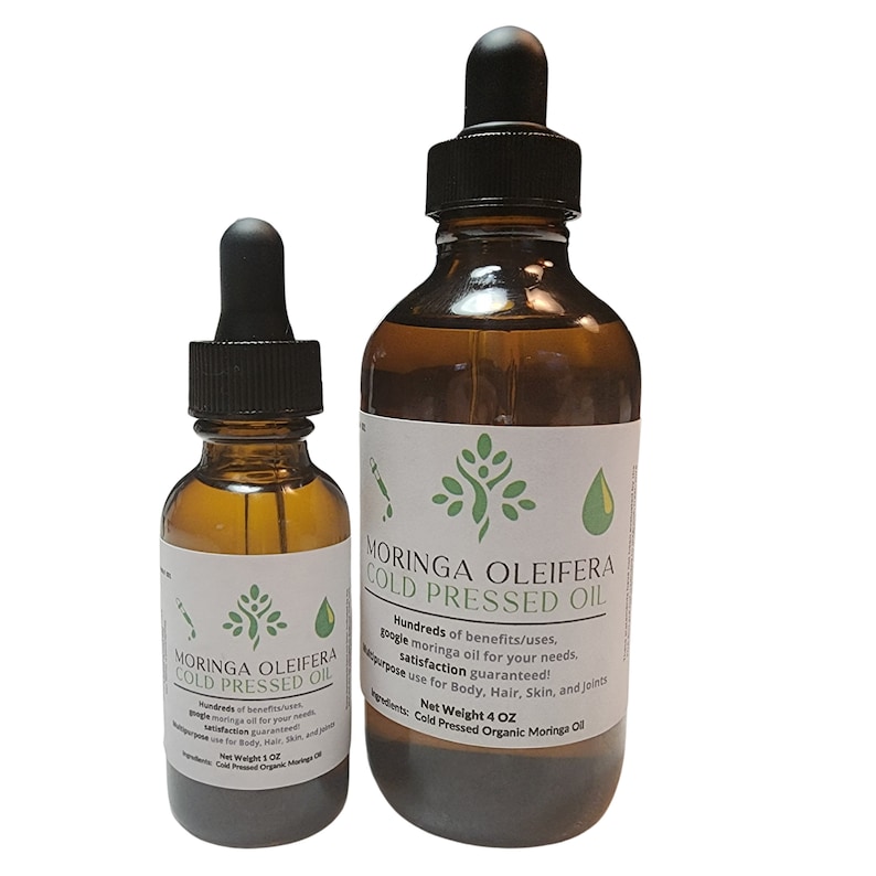 May include: Two amber glass bottles with droppers filled with Moringa Oleifera Cold Pressed Oil. The larger bottle is 4 oz and the smaller bottle is 1 oz. The bottles have white labels with green leaf designs and text that reads "Moringa Oleifera Cold Pressed Oil". Hundreds of benefits/uses, google moringa oil for your needs. Satisfaction guaranteed! Multipurpose use for Body, Hair, Skin, and Joints. Net Weight 4 OZ. Cold Pressed Organic Moringa Oil.