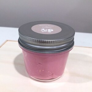 May include: A glass jar filled with pink slime with glitter. The jar has a silver lid with a white label that says "Sleepy Moon Creations".