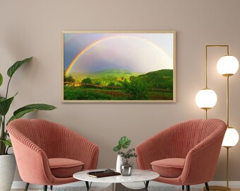 Puede incluir: Dos sillones de terciopelo rosa con una mesa de café de mármol blanco frente a una impresión enmarcada de un arcoíris sobre un campo verde.